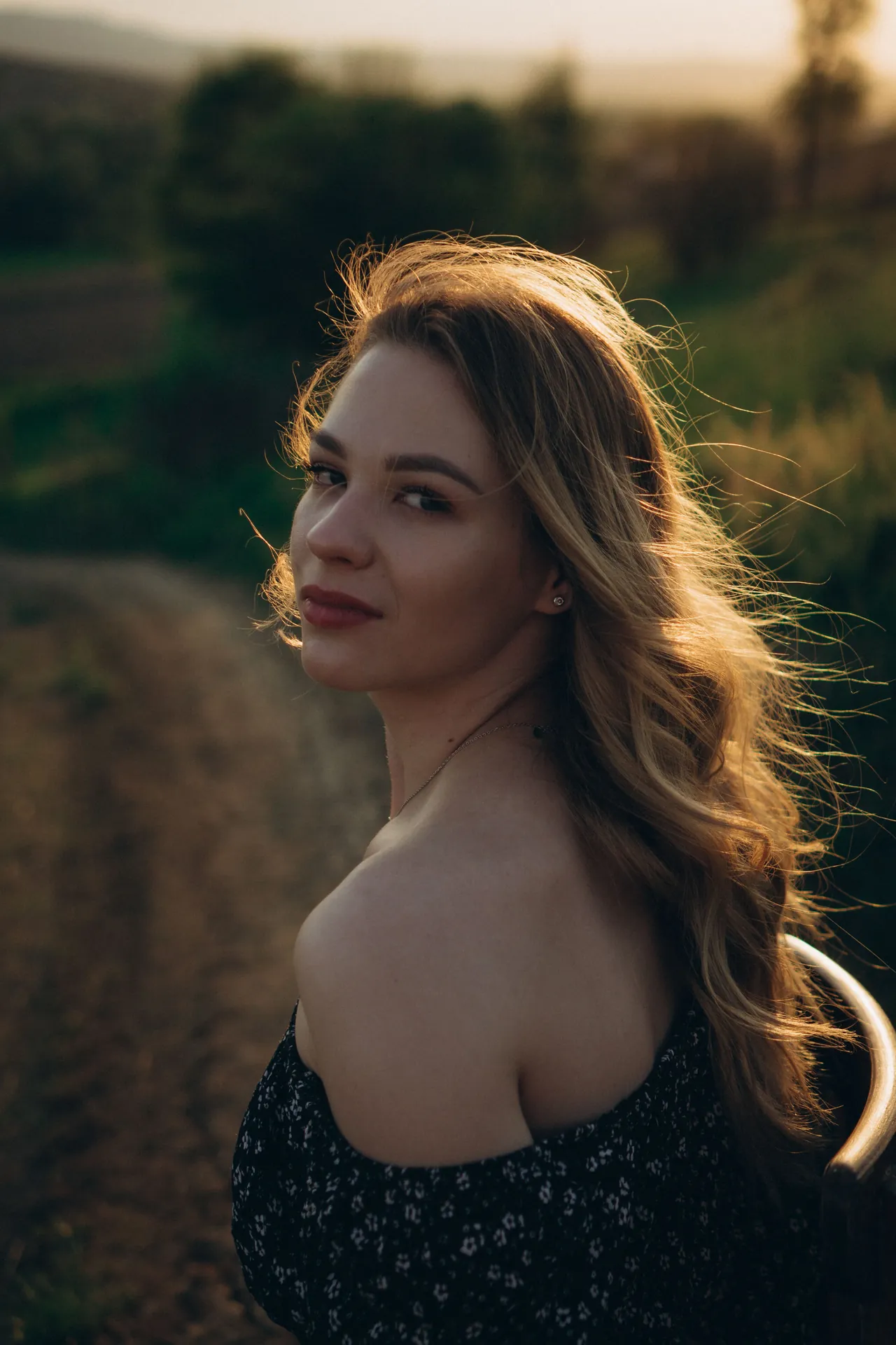 Mulher de cabelo longo solto ao vento, na luz dourada do fim de tarde